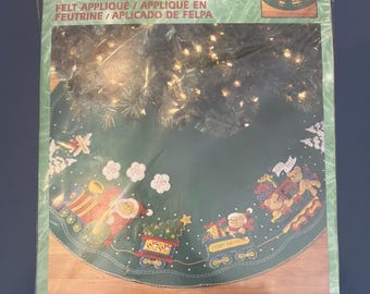 Vintage Bucilla kerstboomrok uit 2001 met applicaties van de kerstman en een speelgoedtrein.