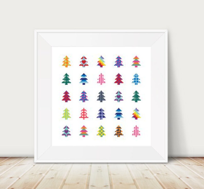 Peut inclure: Une impression encadr&eacute;e pr&eacute;sentant une grille d'arbres de No&euml;l pix&eacute;lis&eacute;s color&eacute;s. Les arbres sont de diff&eacute;rentes couleurs, dont le vert, le rouge, le bleu et le jaune, et ont des motifs diff&eacute;rents. Le cadre est blanc, et le fond est en bois clair.