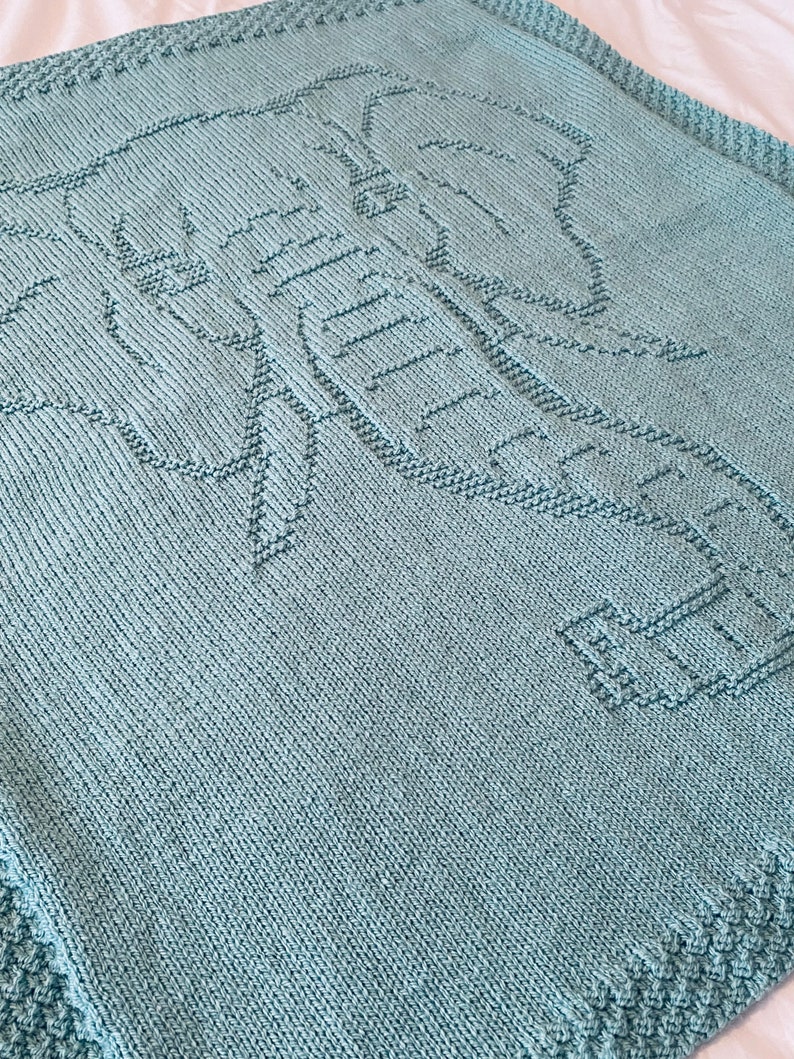 Pode incluir: Um cobertor de beb&eacute; de malha azul claro com um design de elefante.