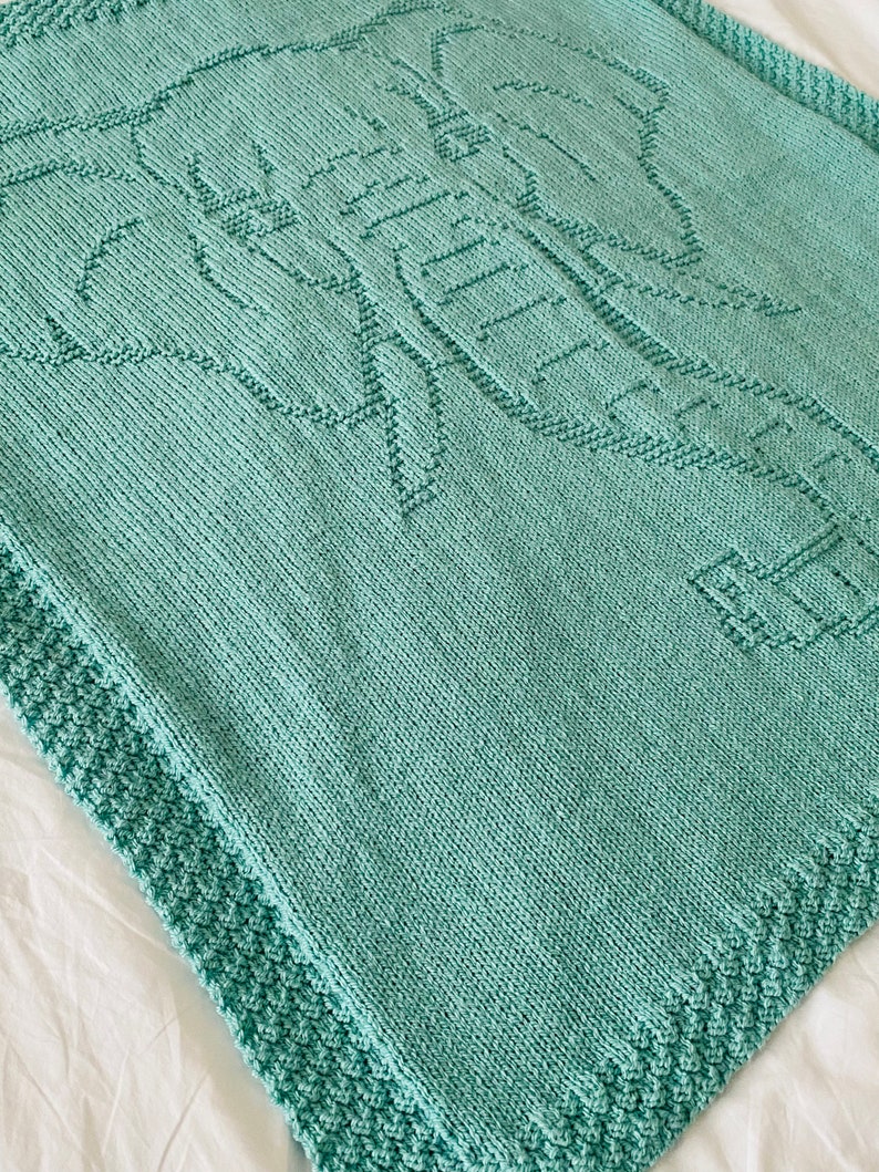 Pode incluir: Um cobertor de beb&eacute; de malha azul turquesa com um design de elefante.