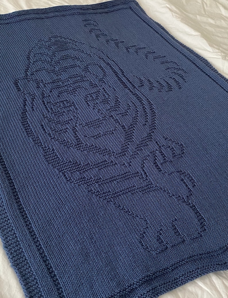 Pode incluir: Um cobertor de beb&eacute; azul de malha com um desenho de impress&atilde;o de p&eacute; de beb&eacute; branco de malha.