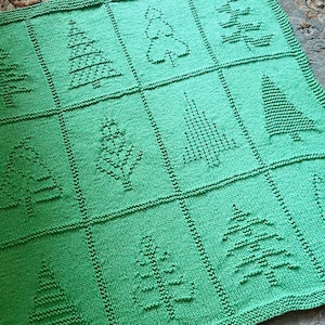 May include: A square, bright green knitted blanket featuring a grid pattern of twelve distinct textured tree designs. Each tree is created using knit and purl stitches, resulting in a raised, tactile pattern against the flat green background.