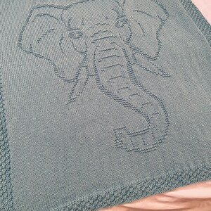 Pode incluir: Um cobertor de beb&eacute; azul claro de malha com um design de elefante.