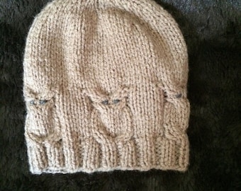 May include: A brown knitted beanie hat with a cable knit pattern.
