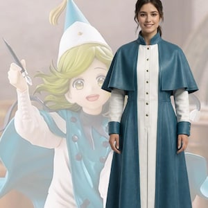 May include: A teal and white long coat with a matching cape. The coat has a high collar and is buttoned down the front. The model is wearing brown boots. A cartoon character in a similar outfit is in the background.