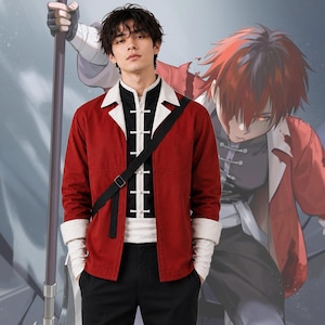 Peut inclure: Veste rouge avec col et poignets blancs, pantalon noir et une sangle noire. La veste a une chemise blanche et noire en dessous. Un personnage de dessin animé est en arrière-plan.