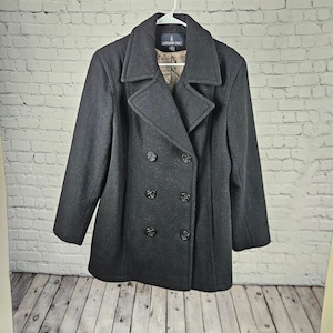 May include: A black double-breasted pea coat with a wide collar, long sleeves, and six dark buttons. The interior lining features a tan and brown patterned print. A black label at the neck displays the white text London Fog in a classic font.