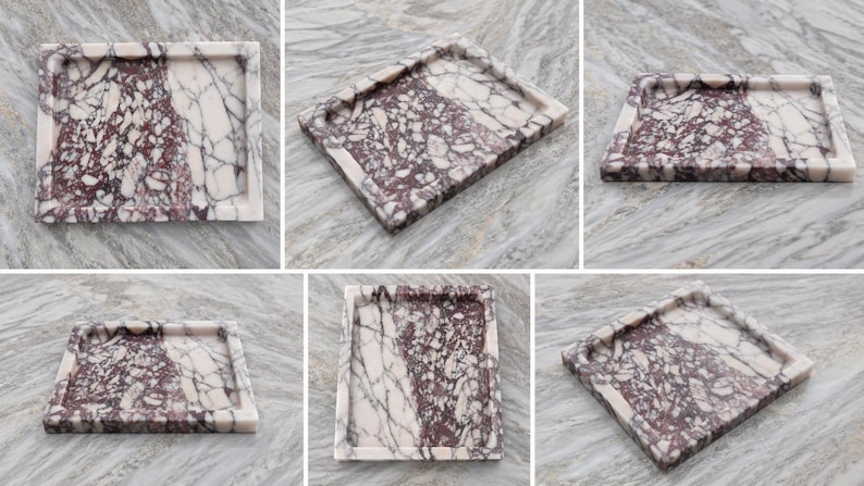 May include: A rectangular marble tray featuring a distinct brecciated pattern with deep burgundy and white veining. The tray has a smooth, polished surface and raised edges, showcasing a natural stone texture with a high-contrast color palette.