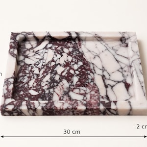 May include: A rectangular marble tray featuring a brecciated pattern of deep burgundy and white stone fragments. The tray measures 25 cm in height, 30 cm in width, and 2 cm in depth, with a raised border surrounding the flat central surface area.