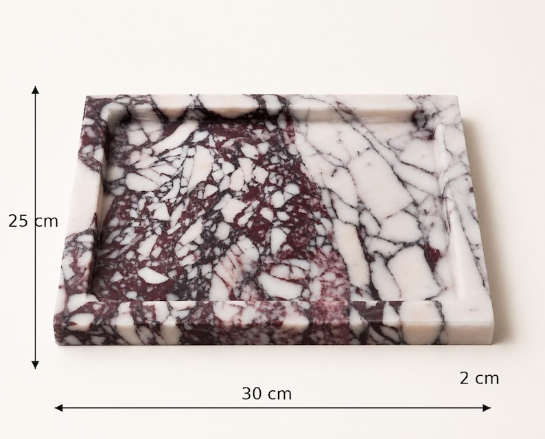 May include: A rectangular marble tray featuring a brecciated pattern of deep burgundy and white stone fragments. The tray measures 25 cm in height, 30 cm in width, and 2 cm in depth, with a raised border surrounding the flat central surface area.