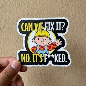 May include: A sticker featuring a cartoon construction worker with the text "CAN WE FIX IT?" above and "NO. IT'S F**KED." below. The worker is wearing a yellow hard hat, blue overalls, and a red and orange plaid shirt.