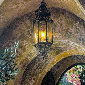 May include: An oil painting depicting a dark metal hanging lantern with a warm yellow glow inside, suspended within a textured, arched stone-colored entryway. Green foliage is visible on the left, and colorful flowers appear in the distance.