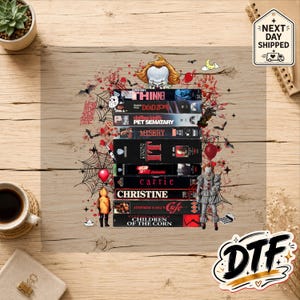 May include: A graphic print featuring a stack of Stephen King VHS tapes including Thinner, Dead Zone, Pet Sematary, Misery, It, The Shining, Carrie, Christine, Cujo, and Children of the Corn, surrounded by horror-themed illustrations like Pennywise.