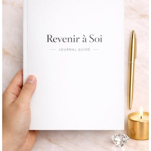 May include: A white journal with the text "Revenir à Soi" and "JOURNAL GUIDÉ" printed in dark gray on the front cover. Beside the journal is a gold-colored metal pen, a small gold-colored candle holder with a lit candle, and a clear crystal diamond.