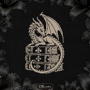 May include: A cross-stitch pattern featuring a beige dragon perched atop a stack of three books, set against a black grid background. The dragon has detailed wings and scales. The text OXtudio is visible at the bottom center of the image.