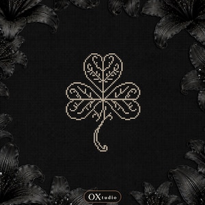 May include: A beige cross-stitch pattern of a three-leaf clover centered on a black grid background. The clover features intricate internal line details. The text OXtudio is printed in a small white oval at the bottom center of the image.