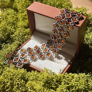 Pulsera ancha de ámbar color coñac hecha a mano en plata de ley, con intrincado diseño floral.