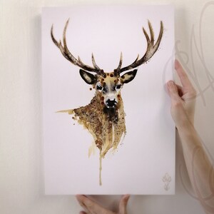 May include: A watercolour painting of a stag with large antlers. The artwork uses a brown and tan colour palette with a splattered effect, creating a textured appearance. The stag's head and neck are the focal point, set against a white background.