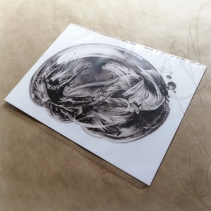 Pu&ograve; includere: Una stampa artistica in bianco e nero con un'illustrazione dettagliata di una creatura mitica all'interno di una bolla. L'opera d'arte mostra un'intricata linea e ombreggiatura, creando un senso di profondit&agrave; e movimento. La stampa &egrave; racchiusa in una custodia protettiva trasparente.
