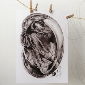 Pu&ograve; includere: Una stampa in bianco e nero di una sirena all'interno di una bolla. La sirena ha lunghi capelli fluenti e una coda dettagliata. La stampa &egrave; firmata ed &egrave; appesa a una corda con mollette di legno.