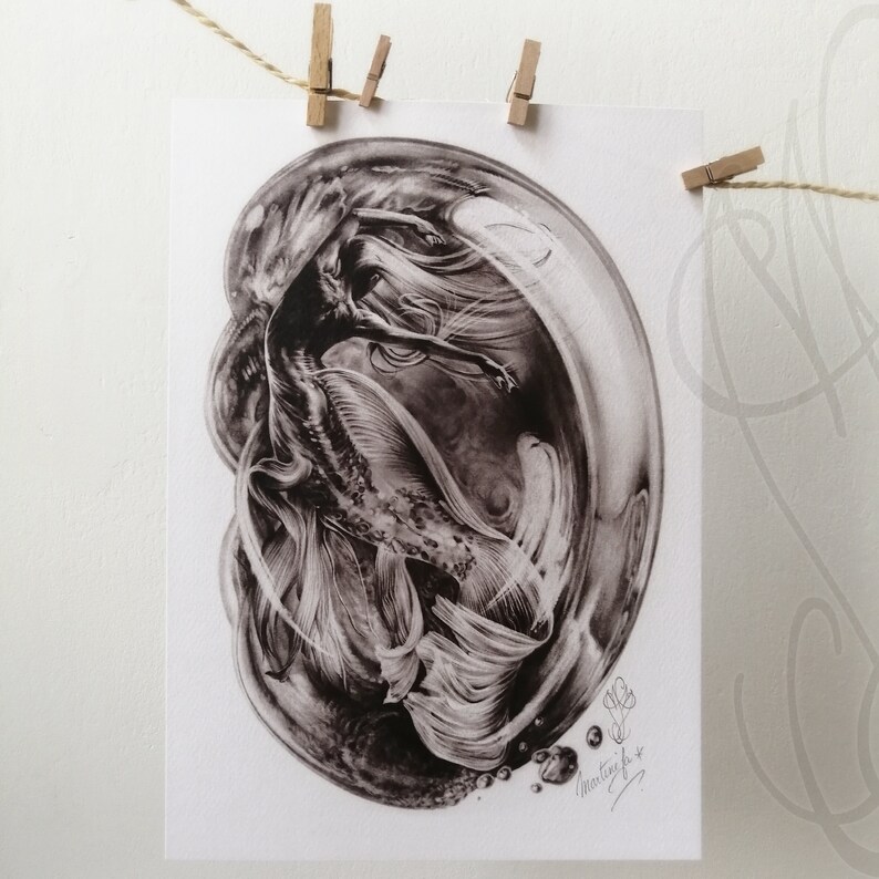 Pu&ograve; includere: Una stampa in bianco e nero di una sirena all'interno di una bolla. La sirena ha lunghi capelli fluenti e una coda dettagliata. La stampa &egrave; firmata ed &egrave; appesa a una corda con mollette di legno.