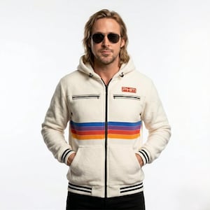 Puede incluir: Sudadera con capucha con cremallera de color crema con un diseño de rayas arcoíris retro en el pecho. Cuenta con detalles en negro en los bolsillos y puños, y las letras "PHM" en la parte superior derecha del pecho. La sudadera tiene una capucha con cordón y un dobladillo a rayas blanco y negro.