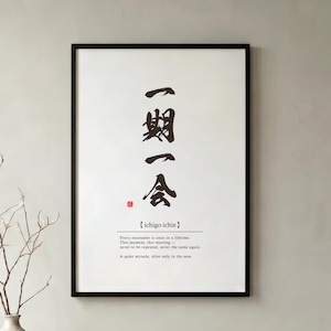 以下が含まれることがあります： 石のベンチの上に、日本語の書道と英語のテキストが書かれた黒いフレームのプリントが飾られています。ベージュの花瓶に枝と2冊の本が置かれ、ベンチは織りのラグの上に置かれています。