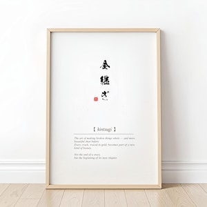 Puede incluir: Impresión artística enmarcada con la palabra japonesa "kintsugi" en caligrafía negra sobre texto en inglés. El texto describe el arte de reparar objetos rotos con oro, creando una nueva forma de belleza. El marco es de color madera clara.