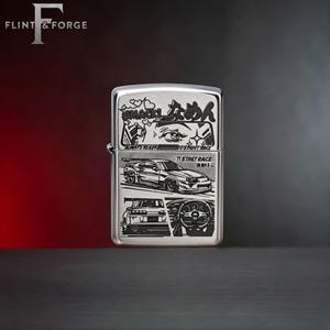 May include: A silver-colored lighter with a detailed graphic design. The design includes Japanese text, car illustrations, and the words "ALWAYS READY" and "TI STREET RACE". The lighter has a hinged lid and a flint wheel.