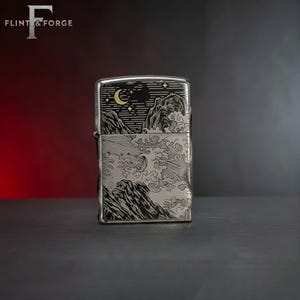 May include: A silver-colored lighter with a detailed engraved design. The design features a night scene with a crescent moon, stars, and stylized waves and mountains. The brand name "Flint & Forge" is at the top left.