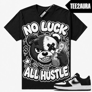 Könnte beinhalten: Ein schwarzes Kurzarm-T-Shirt mit einer Grafik eines zweifarbigen Bären mit genähtem Gesicht, Zahnspange und einer Dollarzeichen-Kette. Der Bär hält einen Stapel Geldscheine. Der Text lautet NO LUCK ALL HUSTLE. Ein schwarz-weißer Sneaker ist abgebildet.