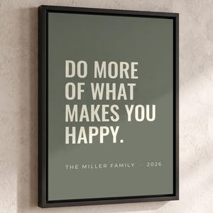 May include: A framed wall art print featuring a sage green background with the white text DO MORE OF WHAT MAKES YOU HAPPY. Below the main text, smaller white text reads THE MILLER FAMILY · 2026. The print is enclosed in a thin black frame.