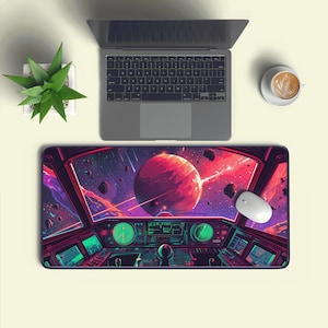 May include: A large rectangular mouse mat with a colourful space scene, including a red planet, stars, and a spaceship cockpit design. A laptop, a white mouse, and a coffee cup are also on a light surface.