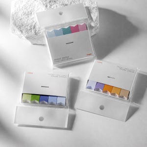 May include: Three clear plastic packages of arrow-shaped sticky notes. Each pack contains five distinct colors of paper flags. The white paper backing on each pack features the text STICKY NOTES, 5 Colors, 10x45mm, 250 Sheets.