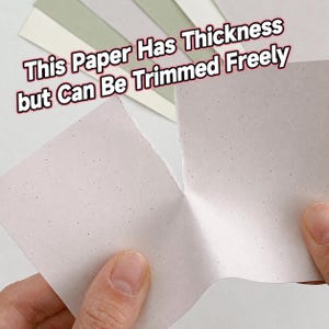 May include: A thick, light-colored paper with small dark speckles being torn in half. The text "This Paper Has Thickness but Can Be Trimmed Freely" is overlaid on the image. Several other sheets of paper in shades of white and green are visible.