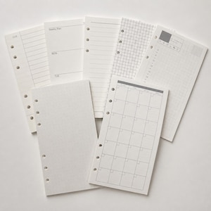 Pode incluir: Um conjunto de folhas brancas para agenda com seis furos perfurados na lateral. O conjunto inclui vários layouts, como um plano semanal, uma grade de calendário mensal, uma página com pontos, uma página pautada e uma página quadriculada.