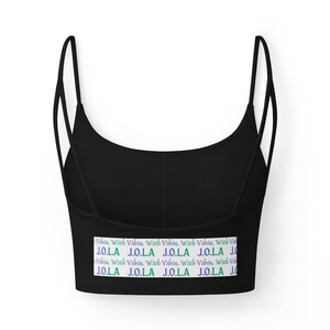May include: Black crop top with thin straps and a scoop neckline. The bottom band features the text "Vibin With Vibin J.O.L.A" in a repeating pattern of white, purple, green, and blue.
