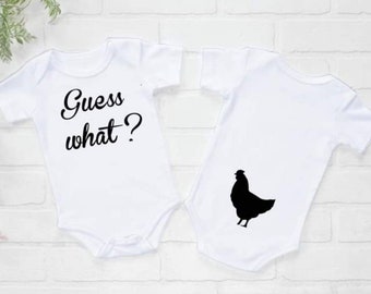 May include: White baby onesie with the text "Guess what?" on the front and a black silhouette of a chicken on the back.