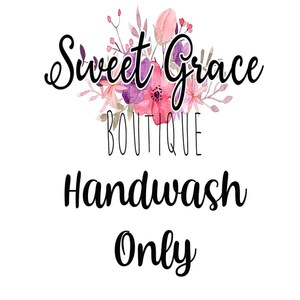 May include: A white background with a floral design in shades of pink and purple. The text "Sweet Grace Boutique" is above the text "Handwash Only".