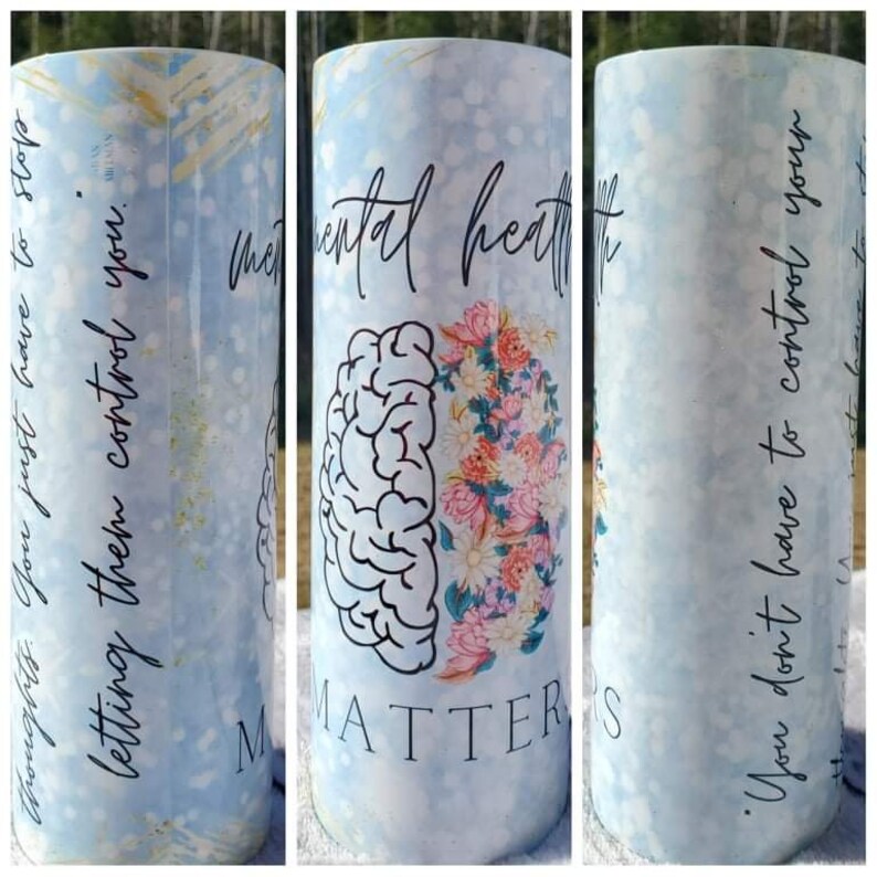 May include: A blue and white tumbler with a floral design and a brain graphic. The text "Mental Health Matters" is written on the tumbler. The text "Thoughts. You just have to stop letting them control you." is written on the left side of the tumbler. The text "You don't have to control your thoughts. You just have to stop letting them control you." is written on the right side of the tumbler.