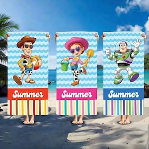 May include: Three beach towels with cartoon characters Woody, Jessie, and Buzz Lightyear. Each towel has a blue wave pattern background and the word "Summer" at the bottom. The towels have colourful striped borders.