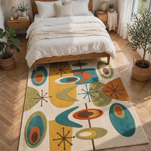 May include: A rectangular area rug featuring a cream-colored background with a repeating pattern of abstract shapes in teal, mustard yellow, olive green, and burnt orange, accented by thin brown starburst lines and concentric oval motifs.