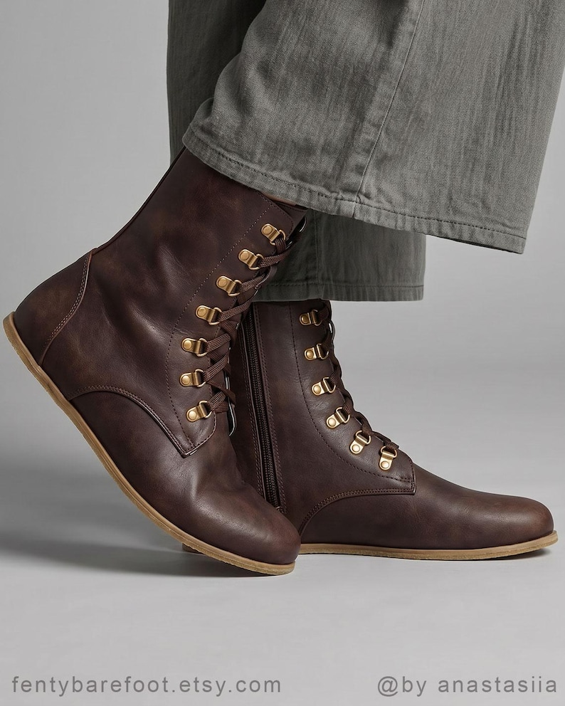 May include: Brown leather boots with gold-colored eyelets and laces. The boots have a side zipper and a flat sole. The boots are worn with gray pants. The Etsy shop name "fentybarefoot.etsy.com" is visible at the bottom of the image.