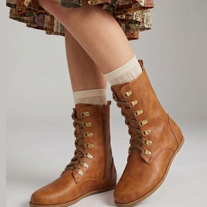 May include: A pair of brown leather lace-up boots with gold-colored eyelets and a side zipper. The boots are worn with cream-colored socks. The Etsy shop name "fentybarefoot.etsy.com" is visible at the bottom of the image.