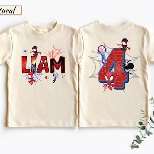 May include: Two natural-colored t-shirts featuring Spider-Man themed graphics. The left shirt displays the name LIAM in red and black letters with spider web accents. The right shirt features a large red number 4 with spider web patterns.