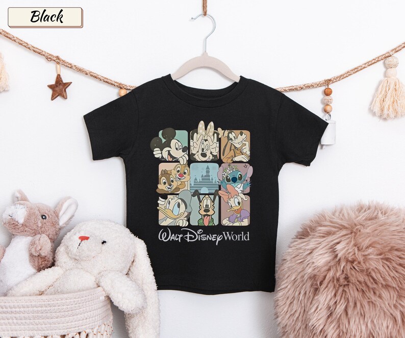 May include: A black short-sleeve t-shirt featuring a grid of nine squares containing illustrations of various Disney characters and a castle. Below the grid, the text Walt Disney World is printed in a white script font on the front of the shirt.