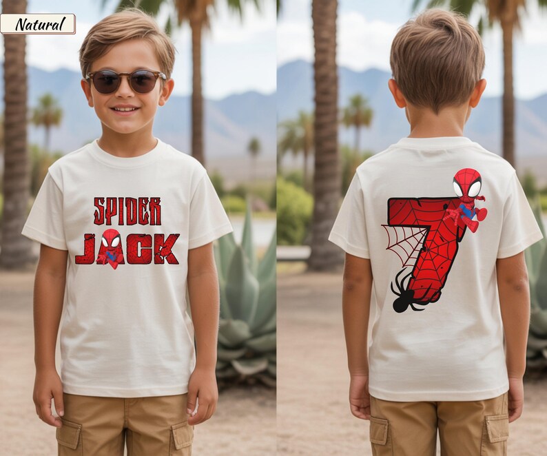 May include: Off-white t-shirt with the text "SPIDER JACK" in red and a Spider-Man graphic. The back of the shirt features a large red number 7 with a spider web and a Spider-Man figure. The shirt is worn by a child.