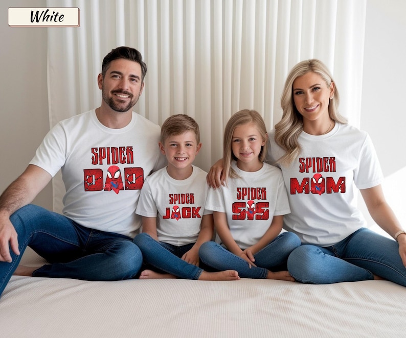 May include: White t-shirts with red and black text that reads "Spider Dad", "Spider Jack", "Spider Sis", and "Spider Mom". The shirts are worn by a family of four, all wearing blue jeans.