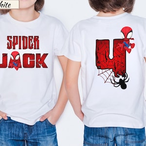 May include: White t-shirt with a red and black Spider-Man graphic. The front of the shirt says "SPIDER JACK" in a distressed font. The back features a large red "U" with a spider web design, a Spider-Man character, and a black spider.