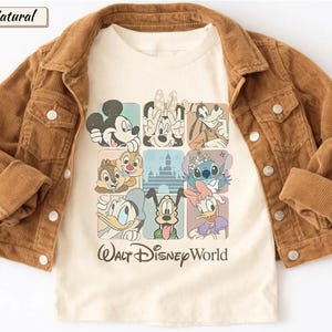 May include: A cream-colored t-shirt featuring a grid of Disney characters including Mickey, Minnie, Goofy, Chip, Dale, Stitch, Donald, Pluto, and Daisy, with a castle silhouette and the text Walt Disney World, layered under a brown corduroy jacket.